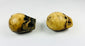 Angled side view of Tibetan Citipati ritual beads showing rounded bone structure, carved facial details, and aged coloration