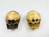 Front view of two Tibetan Citipati ritual beads carved from human femur bone, showing skull faces and suspension holes on a white background.