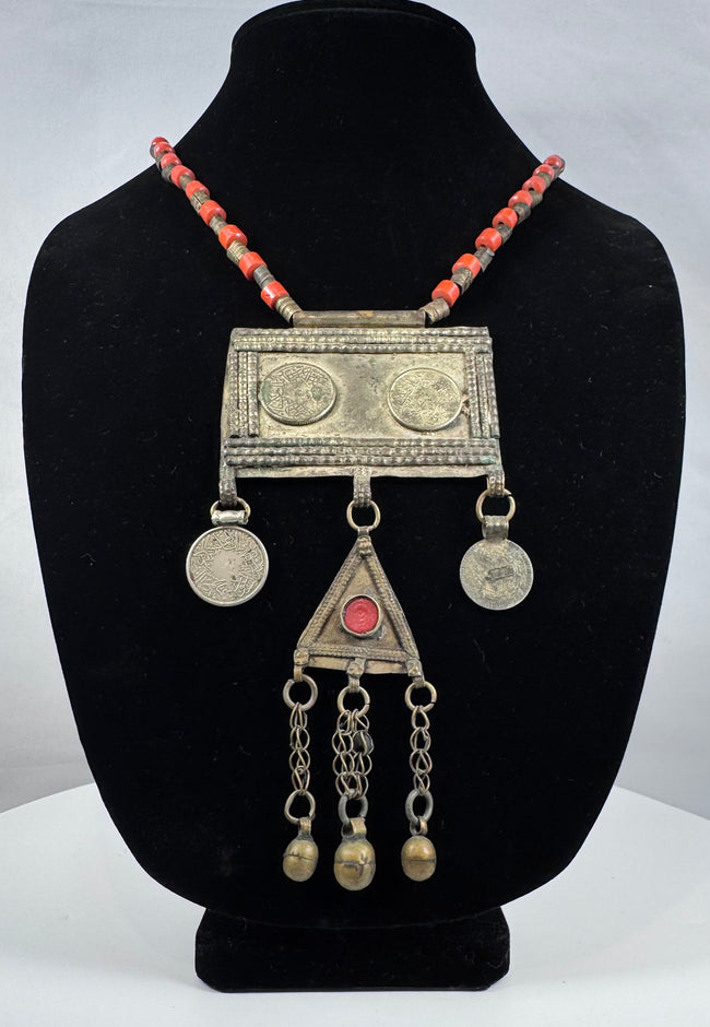 Antique Turkmen tribal jewelry with suspended coin elements, red glass beads, and handcrafted silver-toned metalwork.