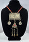Antique Turkmen tribal jewelry with suspended coin elements, red glass beads, and handcrafted silver-toned metalwork.