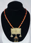 Historic Turkmen tribal necklace displaying traditional Central Asian jewelry with coin elements, red glass accents, and ornate metalwork.