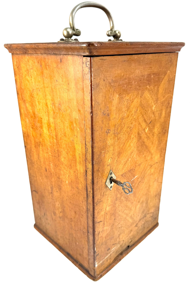 Antique Spencer microscope carrying cabinet with geometric wood veneer, curved metal handle, and front locking hardware.