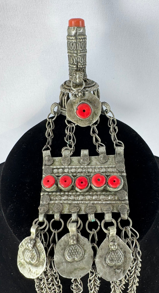Antique Kuchi tribal ornament with a cylindrical prayer tube, decorative medallions, and long suspended chains.
