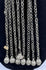 Afghan tribal pendant displaying handcrafted silver-toned metalwork, red glass accents, and ceremonial chain tassels.