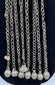 Afghan tribal pendant displaying handcrafted silver-toned metalwork, red glass accents, and ceremonial chain tassels.