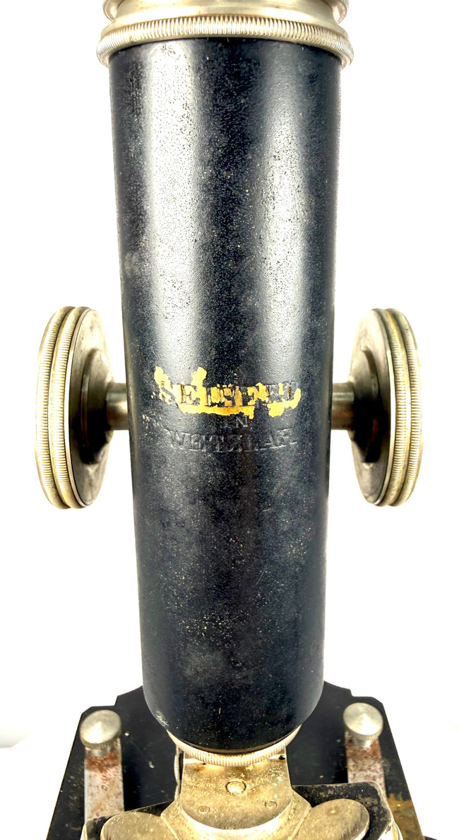 Original gilt Spencer Lens Company manufacturer's marking on the black enamelled optical tube of an early 20th-century microscope.