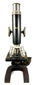 Front view of a Spencer Lens Company laboratory microscope featuring a black cylindrical tube, revolving objective lenses, and horseshoe-shaped base.