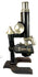 Side view of an early 1900s Spencer compound microscope displaying its specimen stage, focusing mechanism, optical objectives, and metal stand.