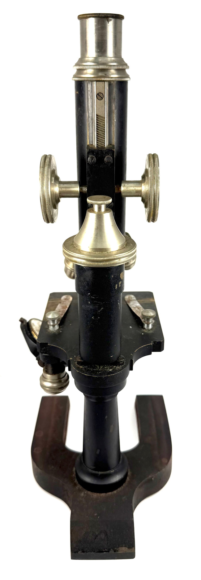 Rear view of a vintage Spencer monocular microscope showing its cylindrical optical tube, focusing controls, supporting stand, and metal base.