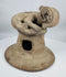 Ancient Ecuadorian terracotta incense burner lid with a sculpted anthropomorphic figure and archaeological patina.