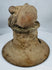 Ancient Ecuadorian ceremonial brazier lid featuring a recumbent figure, large ear ornaments, and vented construction.