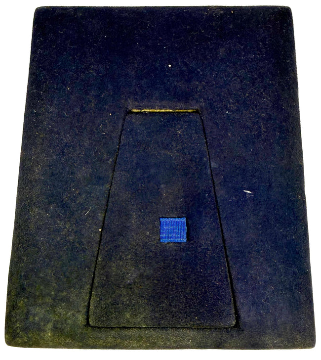 Back of a Victorian velvet photographic presentation case showing the integrated folding easel support and blue textile pull tab.