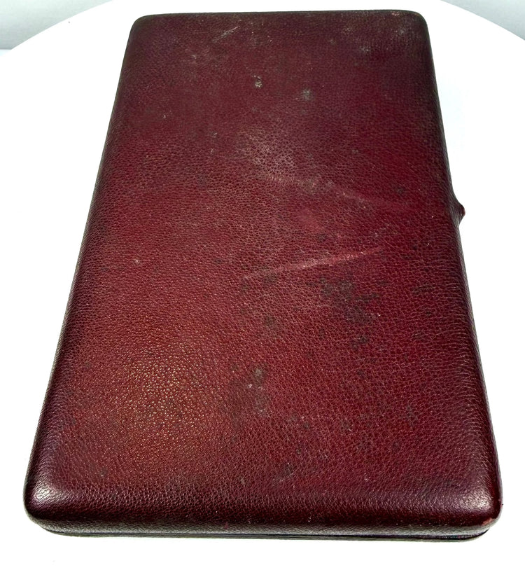 Exterior view of a late Victorian burgundy leather-covered photographic presentation case with visible age-related surface wear.