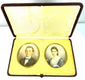 Open antique portrait presentation case featuring two oval colour portraits mounted in cream velvet beneath a patterned satin-like lid.