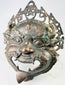 Antique Himalayan bronze guardian mask with wide eyes, incised detailing, and aged ritual patina