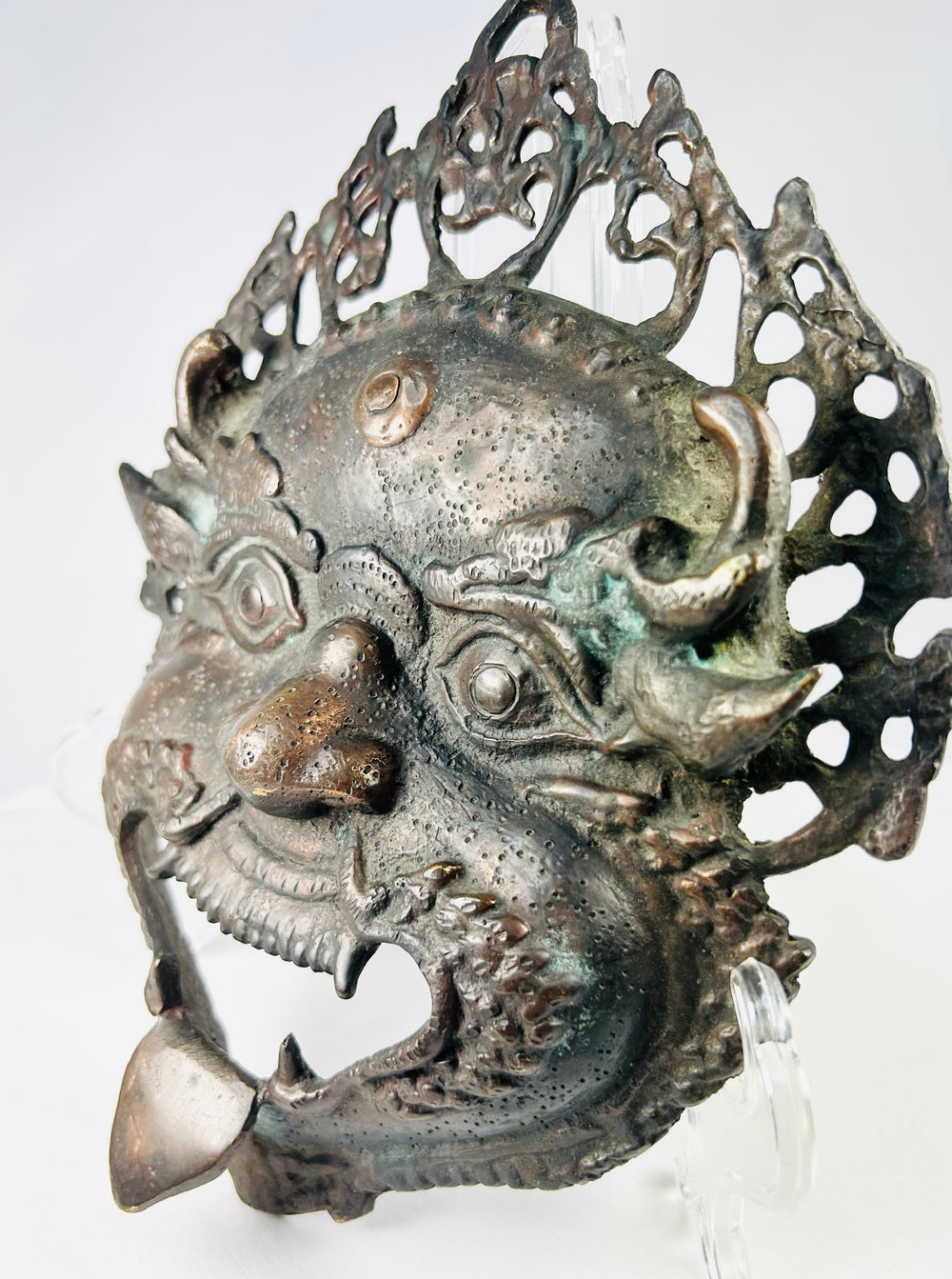 Protective bronze ritual mask from the Himalayan region with remnants of pigment and devotional wear