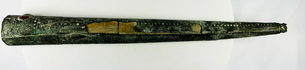 Close-up of the open end of an ancient bronze sword sheath showing interior structure and burial patina from early Etruscan Italy, circa 900–700 BCE