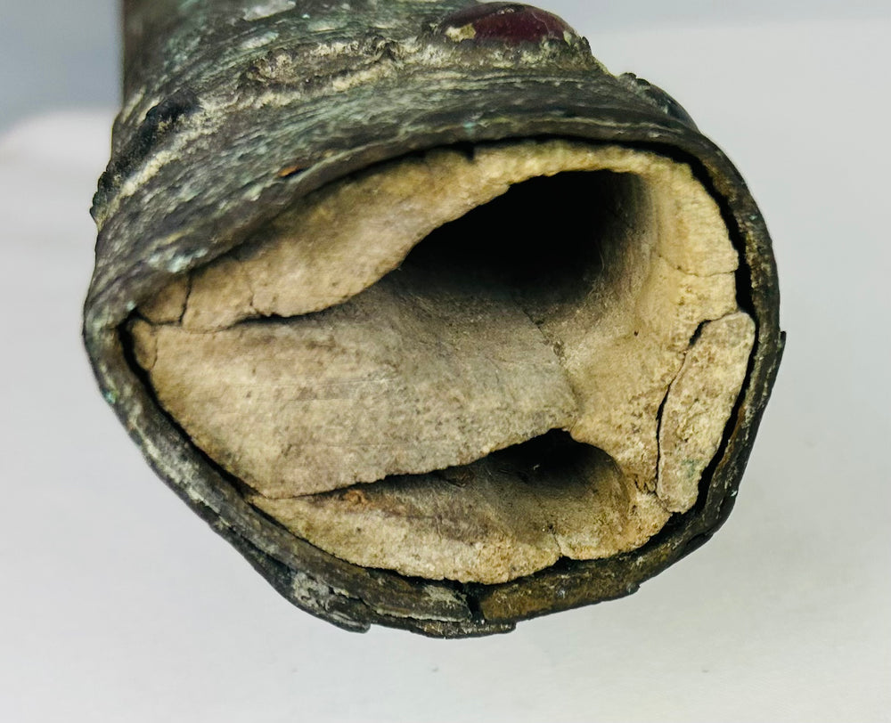 Detail of the pointed end of an Etruscan bronze sword sheath with deep green patina and ancient surface wear – authentic early Etruscan artifact