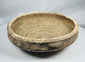 Ancient Roman earthenware bowl from Tunisia with thickened rim, raised central boss, and archaeological mineral deposits.