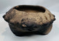Close-up of the modeled zoomorphic heads decorating the rim of an authentic Pre-Columbian terracotta tripod vessel.