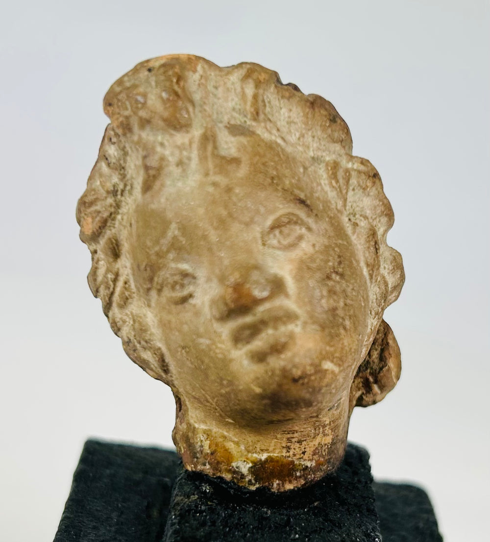 1st millennium BCE–CE head fragment, Greek or Near Eastern origin, patinated terracotta, museum-style mount