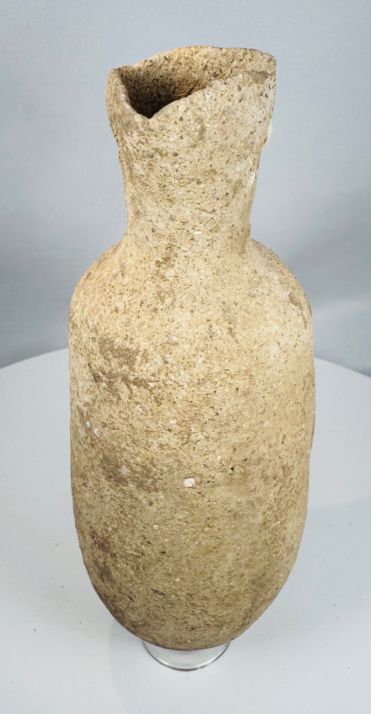 Side view of an ancient Roman Provincial terracotta pouring vessel highlighting its globular form and flared rim.