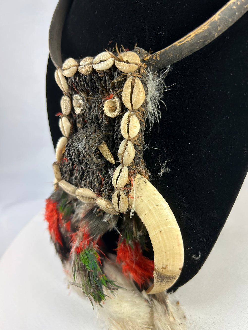 Oceanic tribal necklace combining natural fibers, shell, bone, and feathers