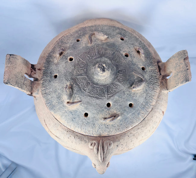 Side profile of an ancient Chinese terracotta ritual vessel highlighting its tripod feet and zoomorphic body.