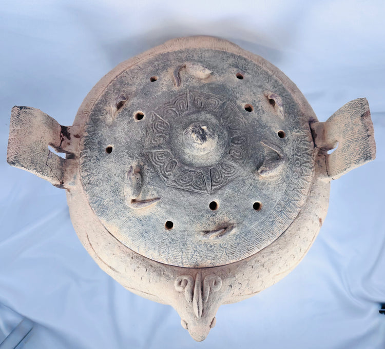 Side profile of an ancient Chinese terracotta ritual vessel highlighting its tripod feet and zoomorphic body.