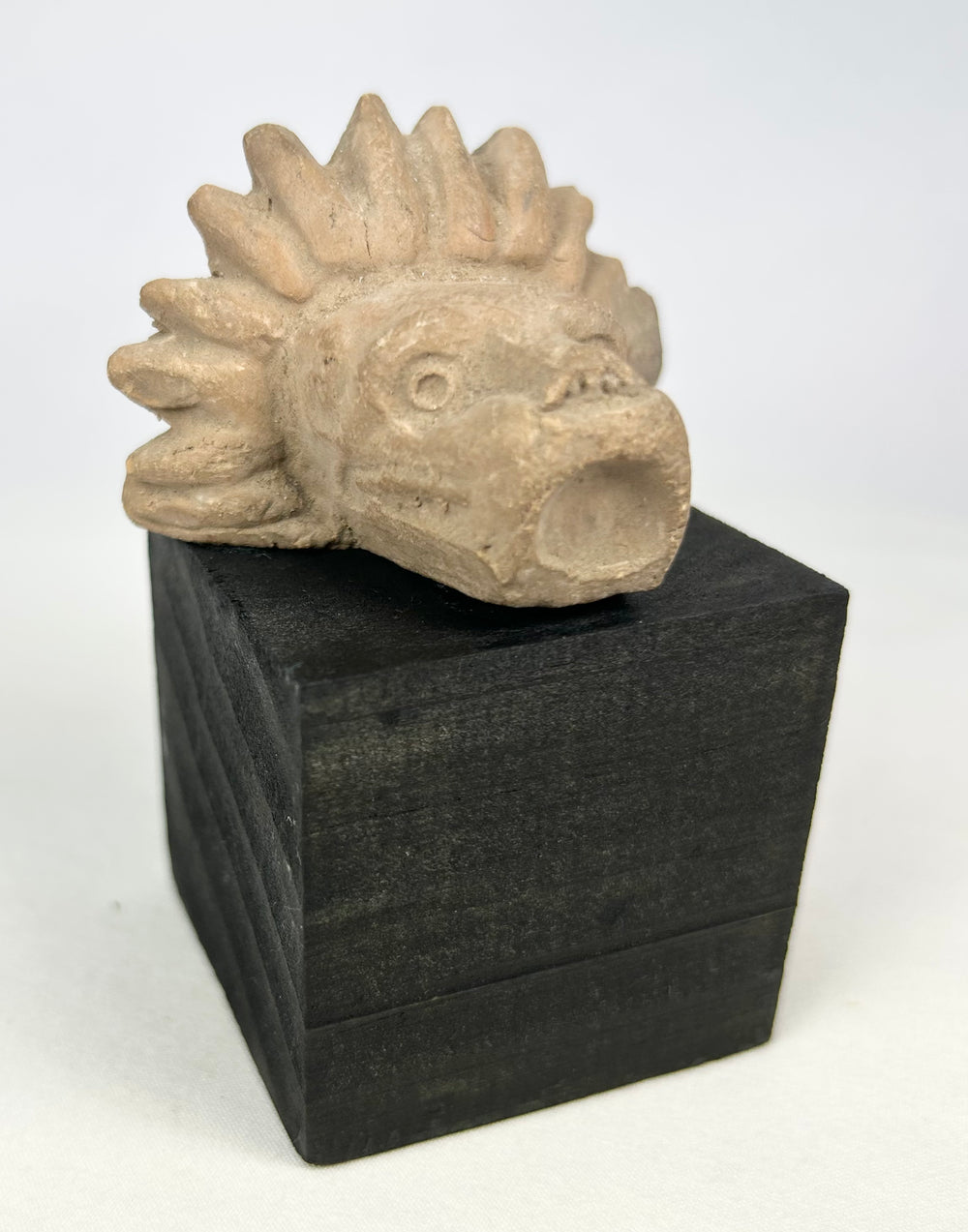 Mesoamerican architectural stone fragment featuring stylized animal head carving