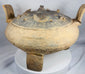 Rear view of a large terracotta ritual vessel from ancient China showcasing its upright handles and sculptural form.