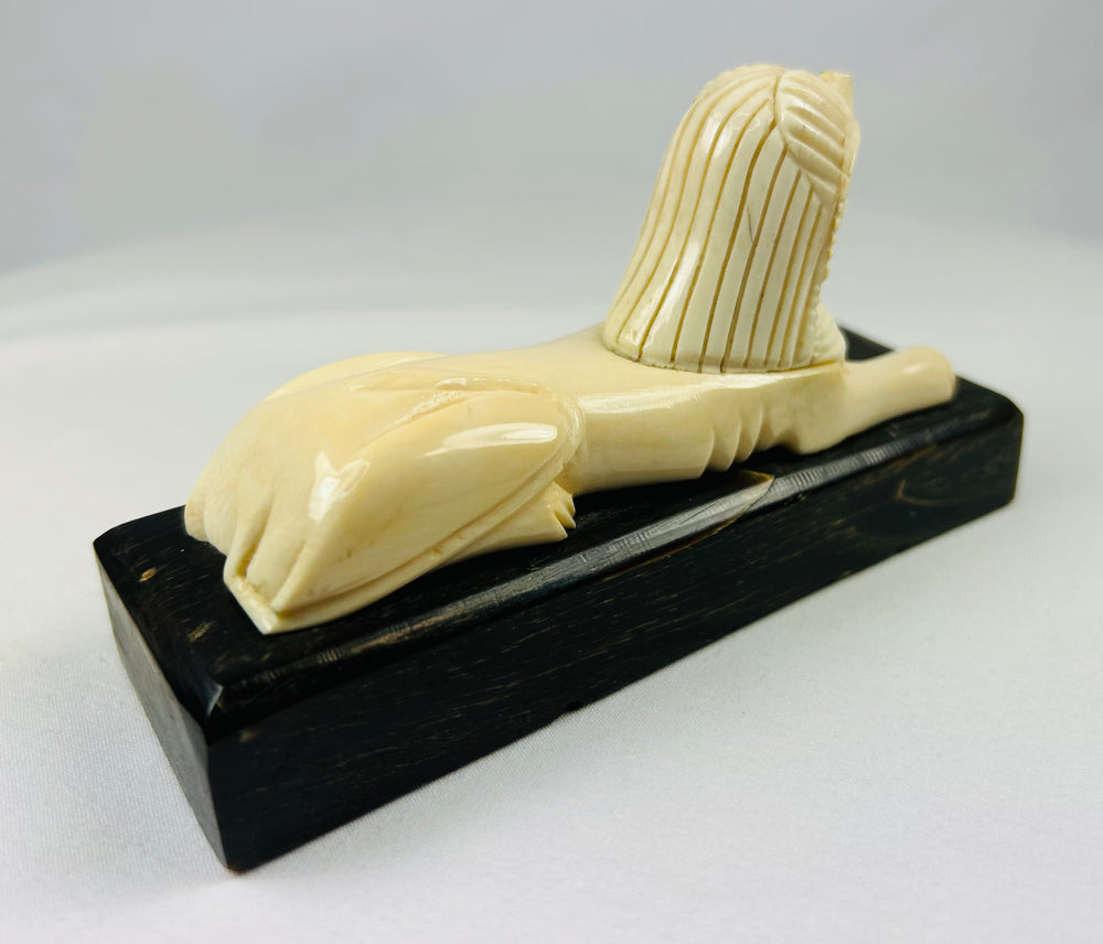 Stylized sphinx figure inspired by ancient Egyptian iconography, 20th century decorative carving