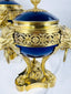 Close-up of a Louis XVI Revival vase displaying cobalt-blue porcelain, lion mask mounts, and ring handles.
