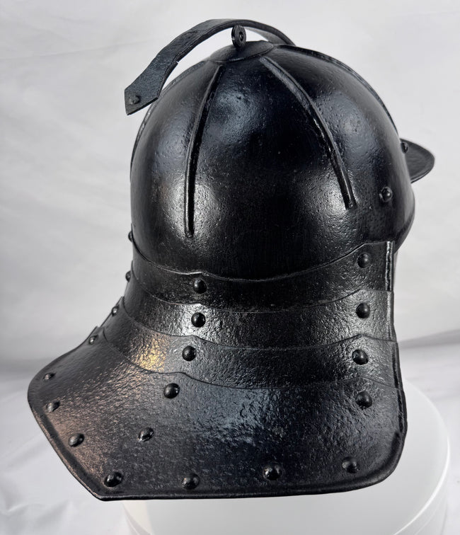 Rare Northern European forged iron combat helmet featuring rolled borders, ring finial, and articulated neck defense.
