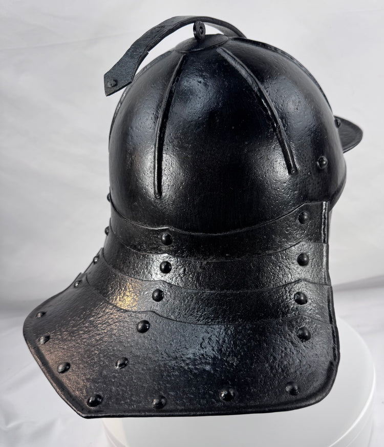 Rare Northern European forged iron combat helmet featuring rolled borders, ring finial, and articulated neck defense.