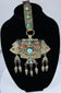 Traditional Himalayan gau amulet case featuring repoussé metalwork, turquoise inlay, and suspended pendant drops.