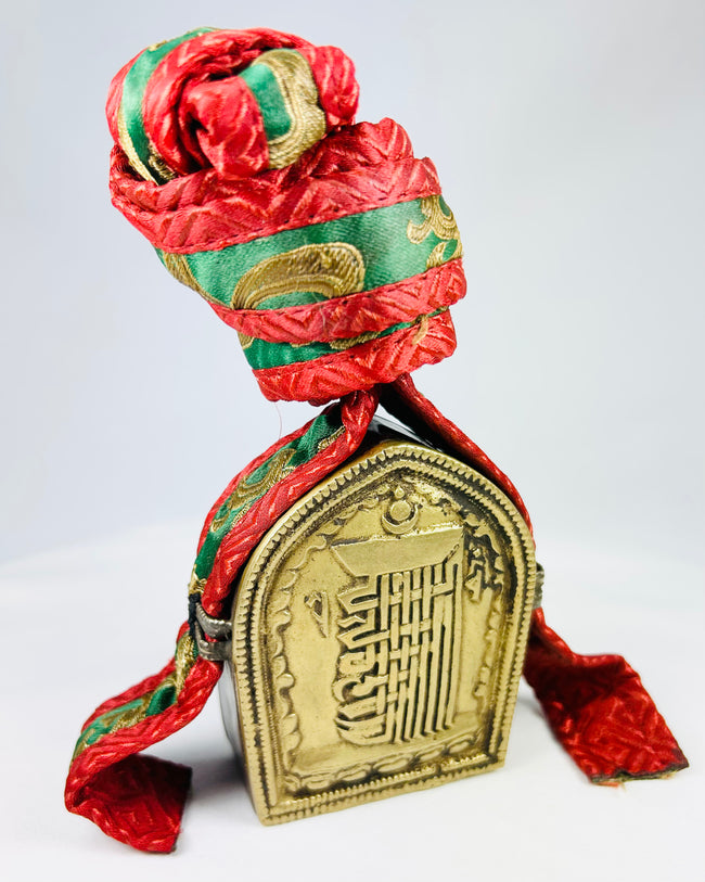 Antique Tibetan gau amulet box featuring repoussé script and traditional embroidered carrying pouch