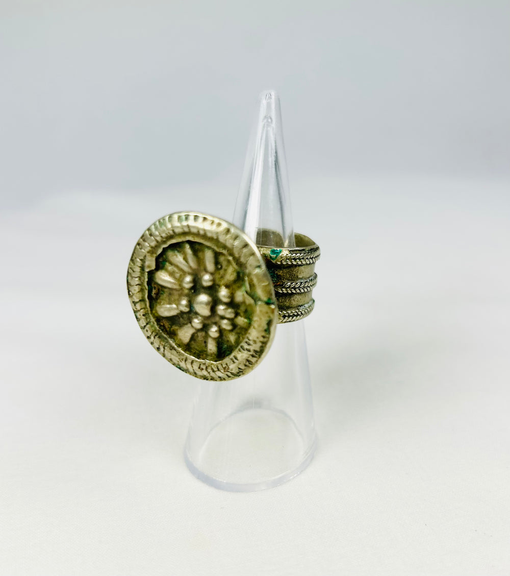 Silver-toned ring with detailed rosette centerpiece and tapered band, 19th century.