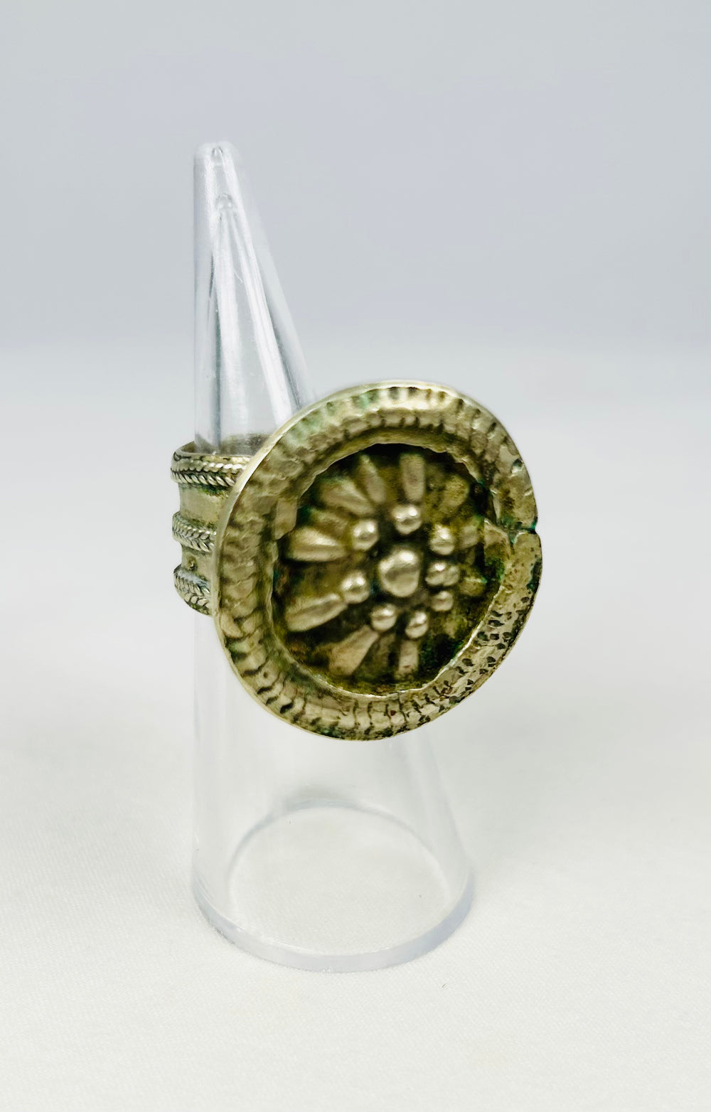 Late 19th century silver-toned ring with raised floral rosette and delicate detailing.