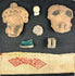 Pre-Columbian shadowbox with terracotta fragments, figurines, and red patterned textile on white background