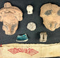 Pre-Columbian terracotta fragments and red geometric textile, framed in shadowbox for display