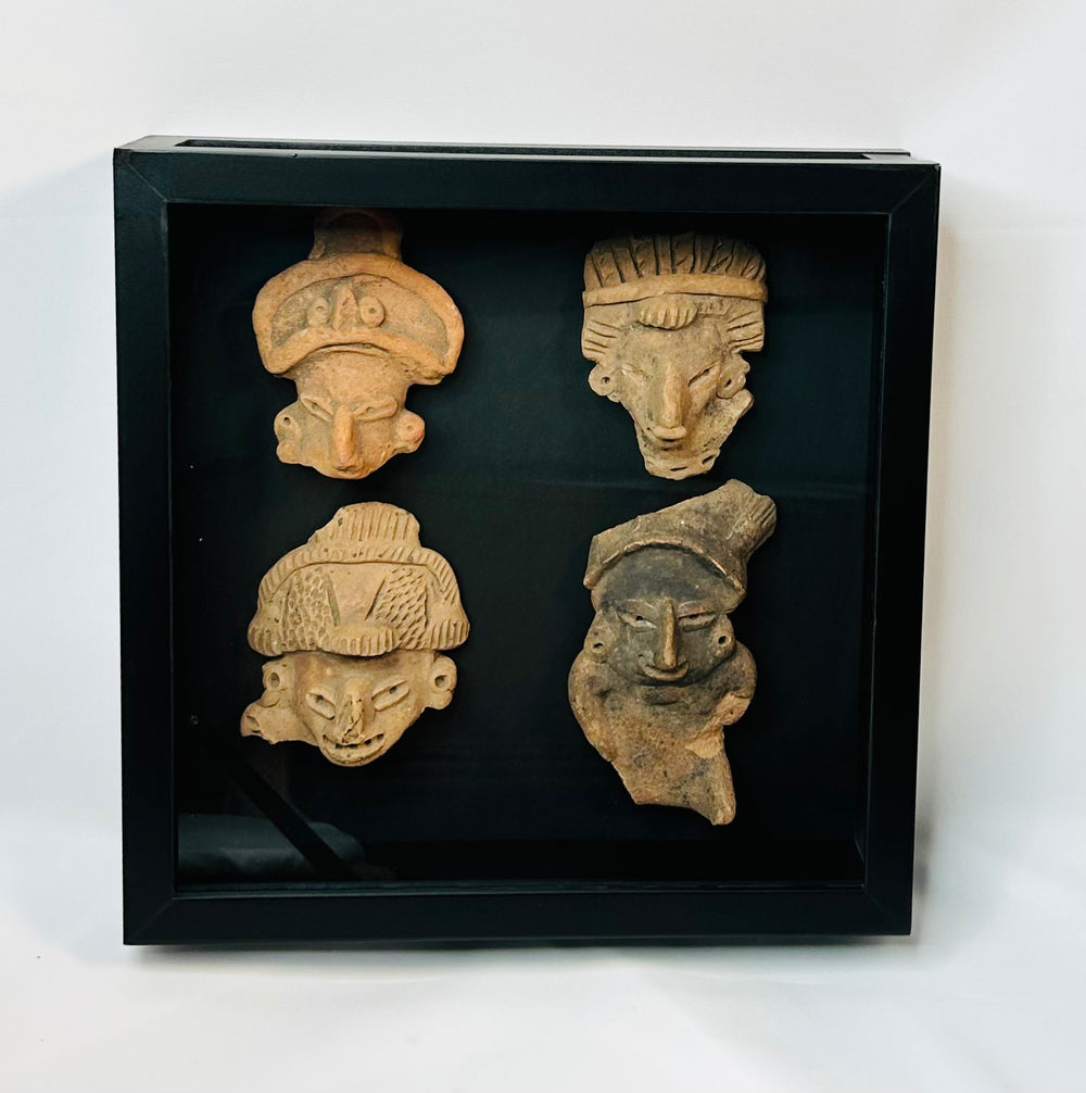 Ancient terracotta face fragments with expressive features, Pre-Columbian display