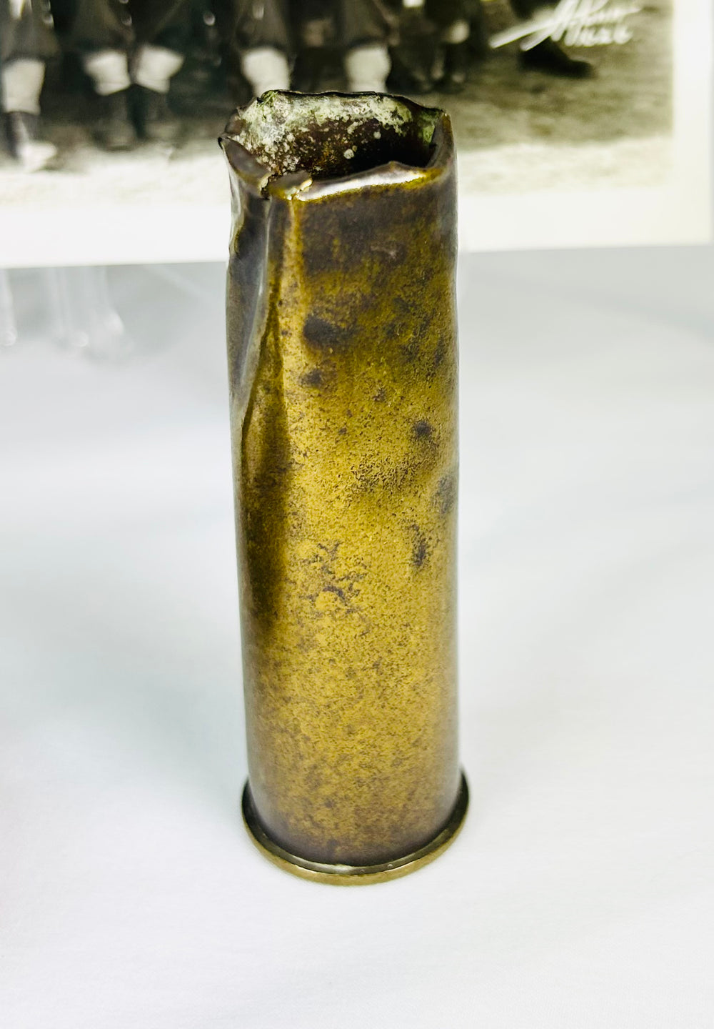 WWI military display with wrist compass, shell casing, and historic unit photograph