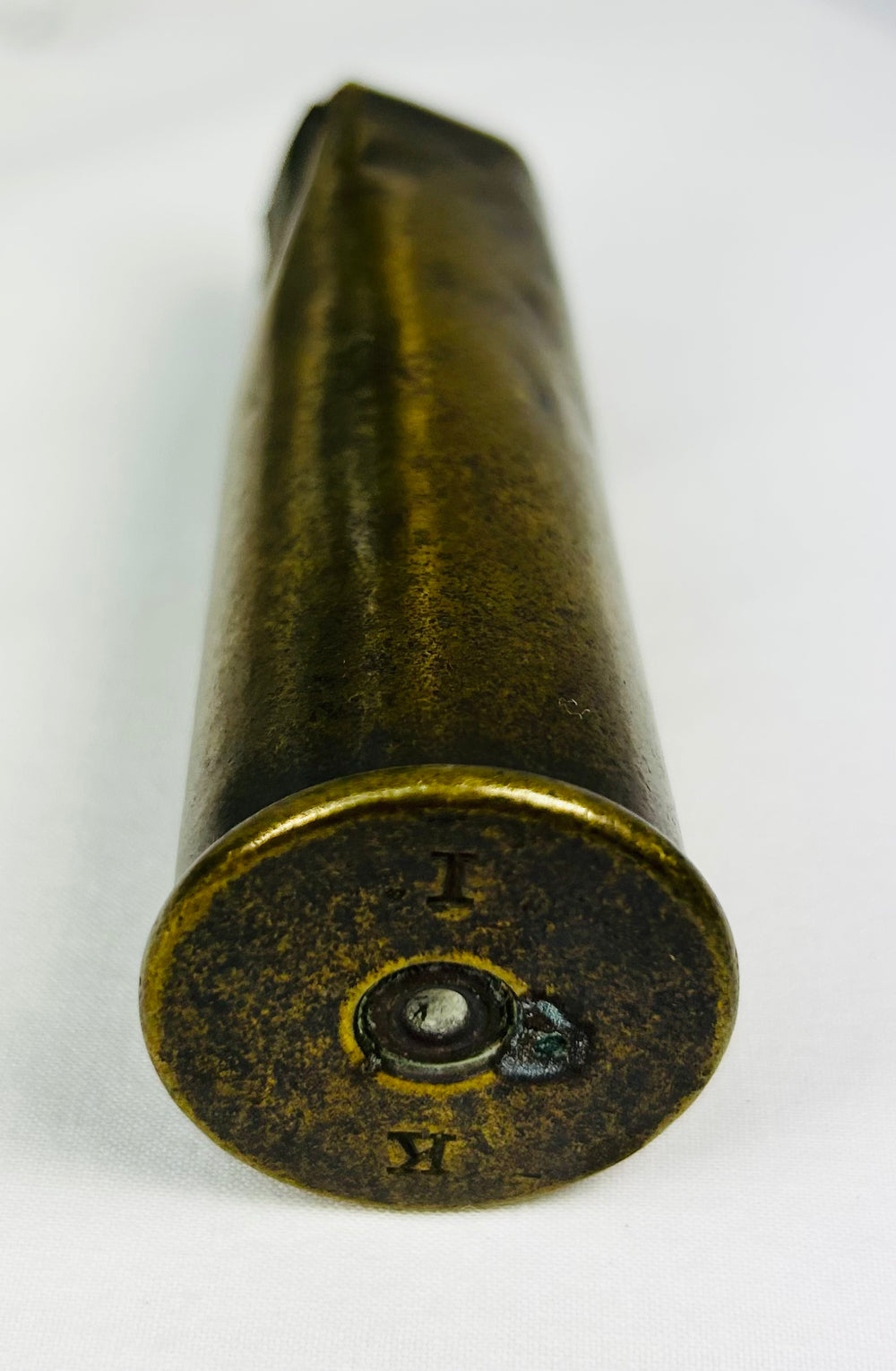 WWI-era military artifacts including soldier’s compass, shell casing, and unit photo on white background