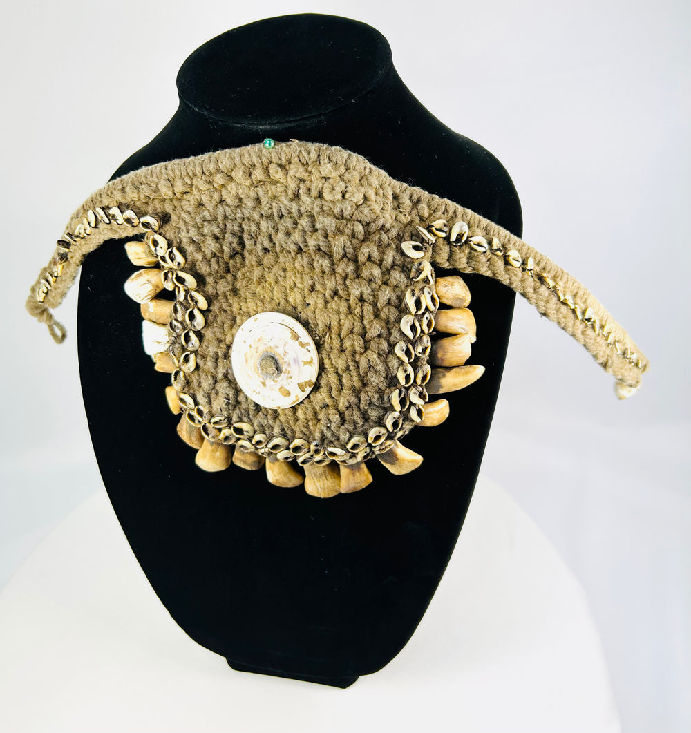 Antique Melanesian ceremonial ornament featuring cowrie shell and woven fiber base