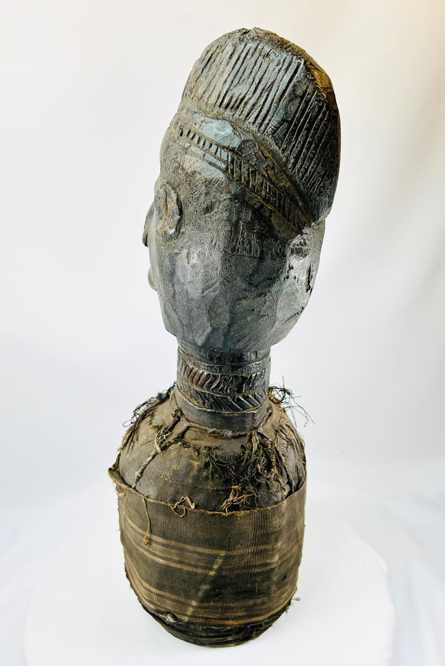 Central or West African carved wooden figure with elongated face and preserved decorative fibers