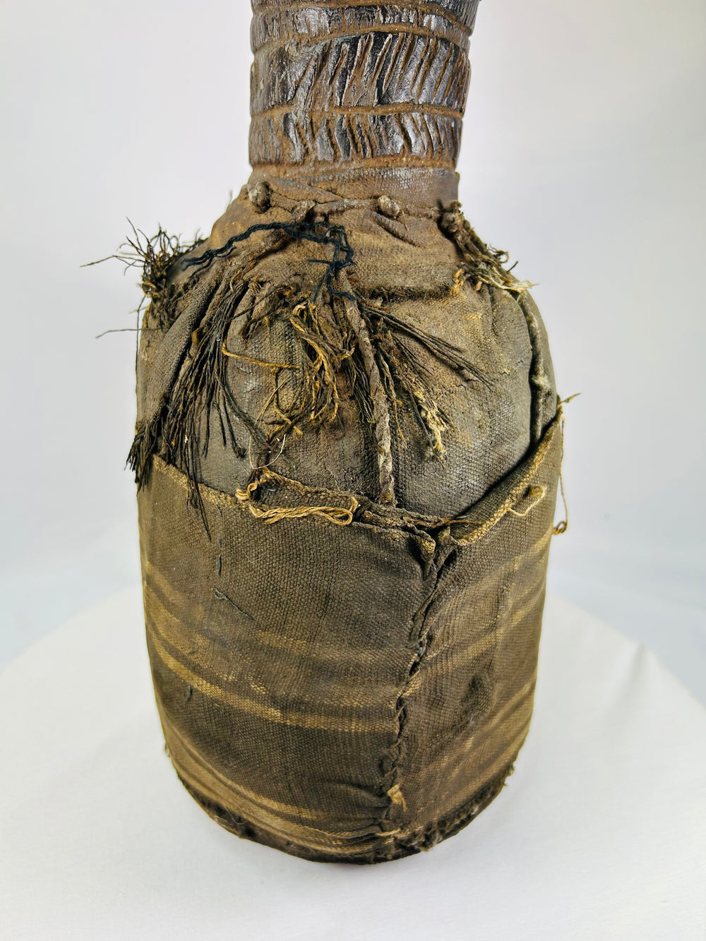 Wooden anthropomorphic figure from Central or West Africa with fiber torso wrapping and carved details