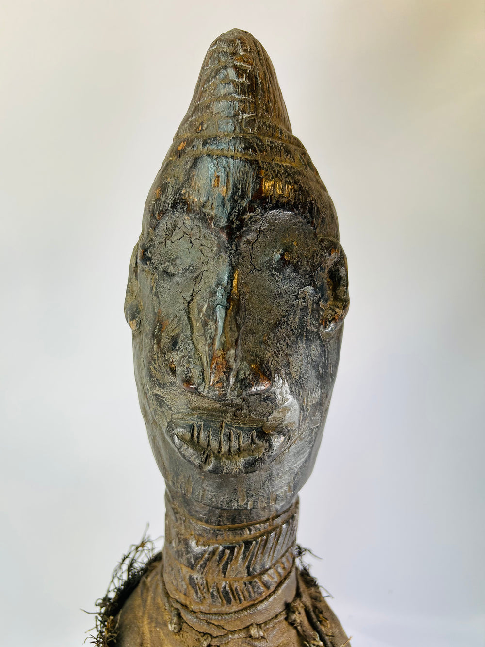 Central or West African wooden figure, hand-carved with elongated face and fiber torso wrap