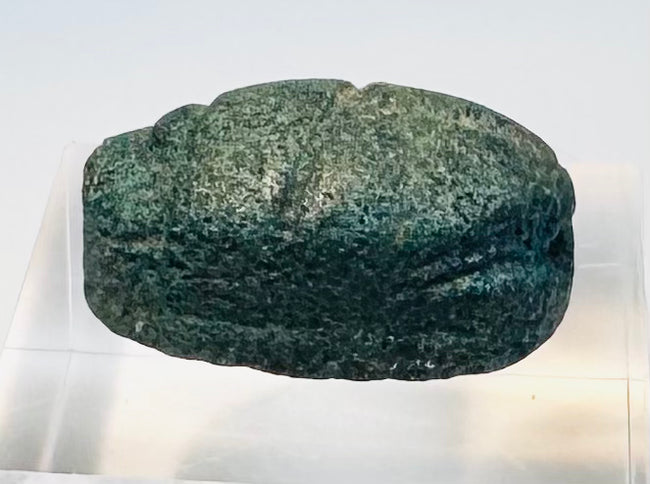 Side profile of blue-green Egyptian scarab showing preserved glaze and beetle form