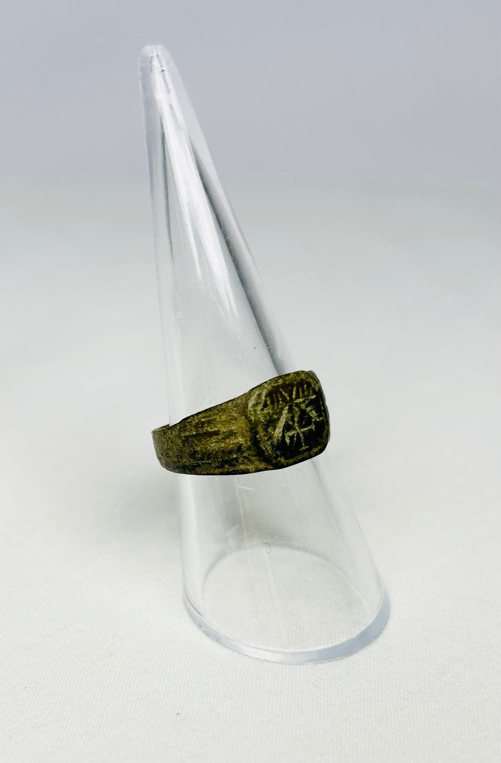 Angled view of ancient Roman bronze ring with dark patina, Chi-Rho engraving, early Christian era artifact, 1st–4th Century CE.